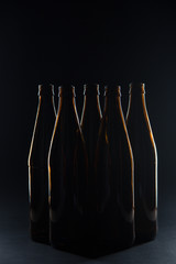 Silhouettes brown glass bottles for beer on a black background