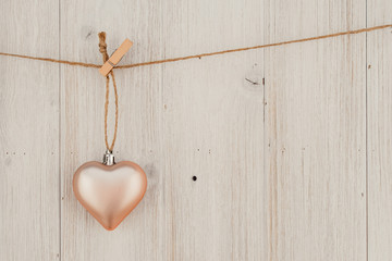 Heart hanging on the clothesline. On old wood background