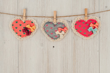 Heart hanging on the clothesline. On old wood background