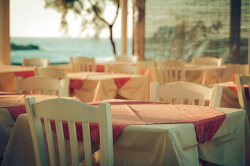 Fototapeta na wymiar traditional greek outdoor restaurant on terrace overlooking Mediterranean sea Greece . empty table at an street sea restaurant.