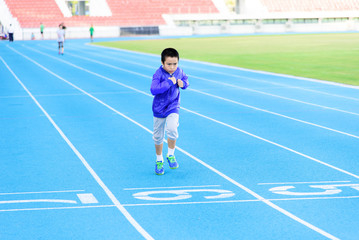Fototapeta na wymiar Boy runnin on blue track