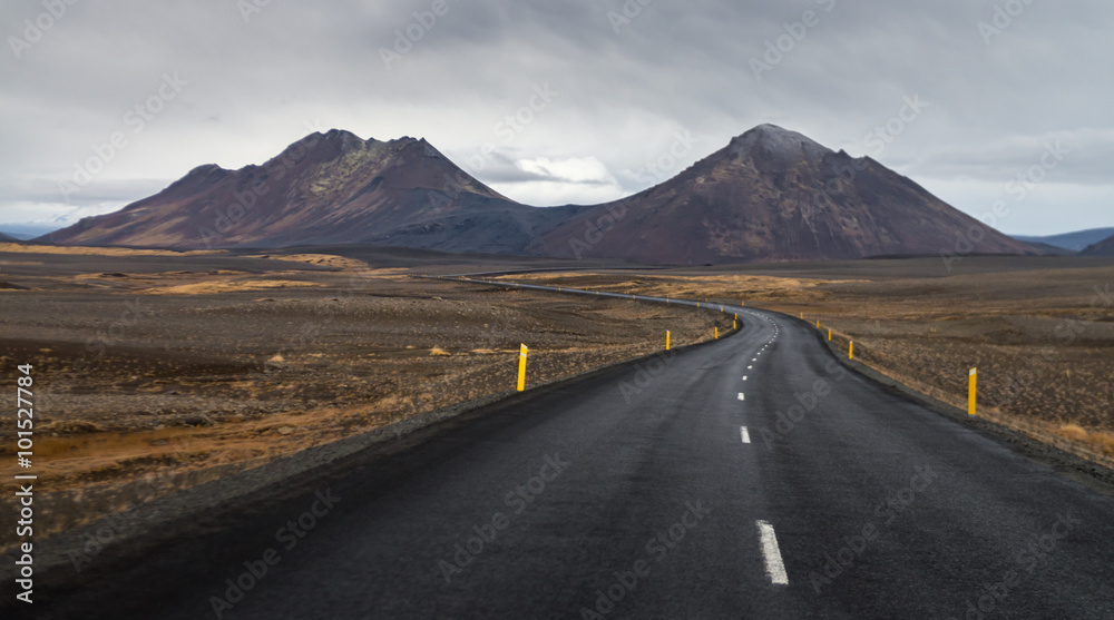 Wall mural Dark asphalt road perspective with yellow field hill and mountain range background in Autumn season Iceland