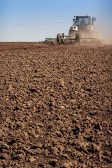 tractor cultivator raises great dust on soil