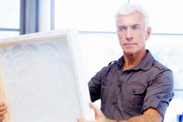 Man standing in a gallery and contemplating artwork