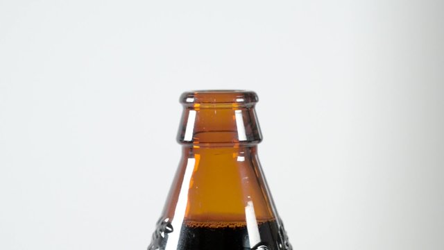 Removing bottle top from a brown irish stout bottle
