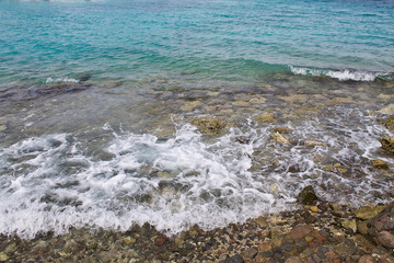 Fototapeta na wymiar Marine rocky shore with clear water and waves