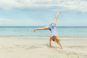 Fototapeta na wymiar Young woman jumping on beach