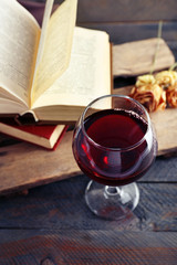 Beautiful composition with glass of wine with old books on table close up