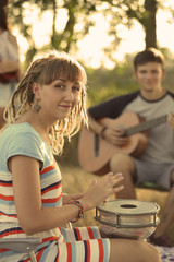 Pretty young girl inspired with a drum