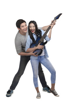 Happy asian couple playing guitar