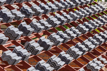 roof under construction with stacks of roof tiles for home build