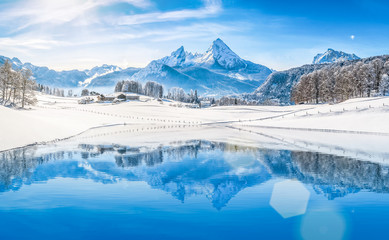 Winter wonderland in the Alps reflecting in crystal clear mountain lake