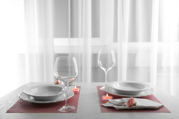 Table setting for two person with dishes and cutlery on pink napkin