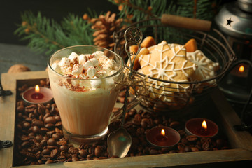 Cup of hot cacao with marshmallow and cookies on coffee beans