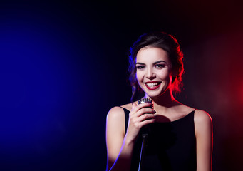 Portrait of beautiful singing woman on dark background