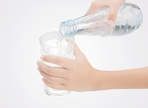 Drinking water is poured from a bottle into a glass