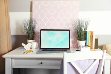 Workplace with table and laptop in living room