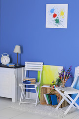 Room design with white furniture, bookcase, pictures, flowers over blue wall