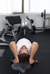 Leg raise, on bench,man raising legs,in gym,fitness