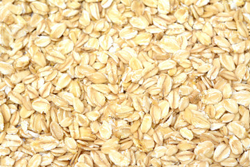 Fresh oat flakes spread out in the background