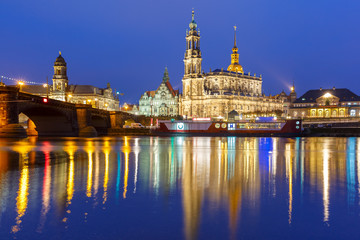 Dresden Cathedral of the Holy Trinity aka Hofkirche Kathedrale Sanctissima Trinitatis and Augustus Bridge with reflections in the river Elbe at night in Dresden, Saxony, Germany