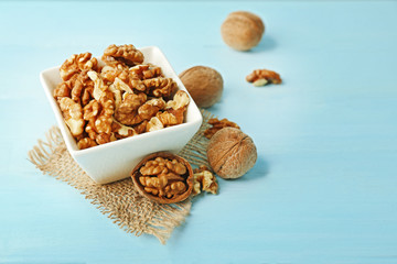 Walnuts in the bowl on blue wooden background