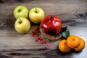assorted tangerine kiwi apple lemon and pomegranate on Rustic Wooden Table