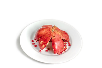 a pomegranate fruit on a plate isolated on white