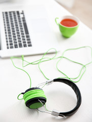 Headphones and laptop on white table against defocused background