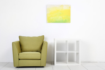 Living room interior with green armchair and white shelf on white wall background