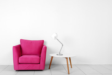 Living room interior with pink armchair, white table and lamp  on white wall background