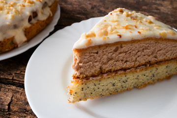 Homemade cake with nuts on a white plate wooden background