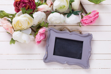 Border from flowers  and empty blackboard on white wooden backgr