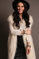 woman with dark hair and smokey eyes makeup,wears luxurious fur coat,