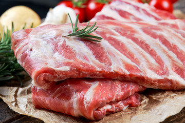 Raw ribs with a rosemary and vegetables. on crumpled paper