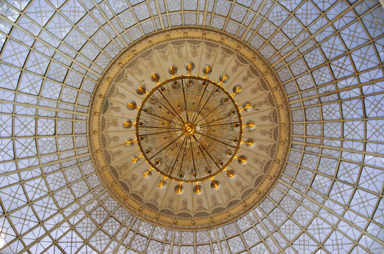 Gold Chandelier Under A Glass Dome In The Interior