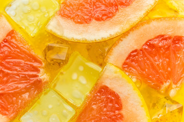 Close-up of ice cubes in orange and grapefruit juice 