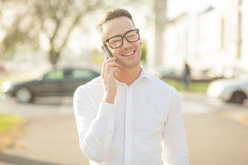 Man with glasses speak on mobile phone in hands