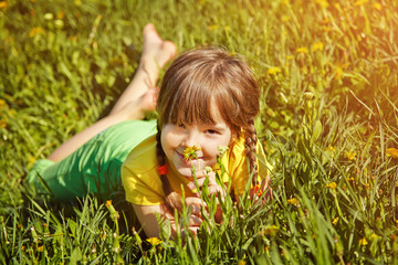 girl sitting in the grass with dandelion