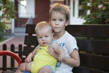 Fototapeta na wymiar funny little children brothers sitting on bench 