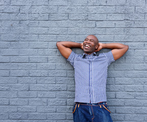 Cheerful african man standing with his hands behind head