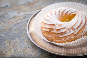 Cake topped with powdered sugar on a metal plate
