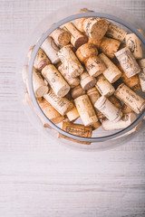 Glass vase with corks on the wooden table