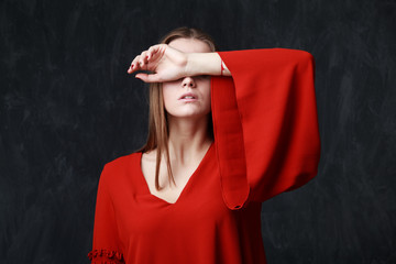 Close up portrait of a beautiful sad woman in red dress