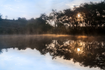 Obraz na płótnie Canvas Sunrise, the mist over the lake.