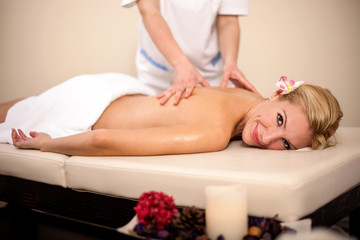 Fototapeta na wymiar professional masseur doing massage of female back in the beauty