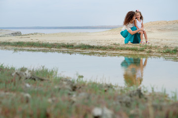 young mother with a child walking along the seashore