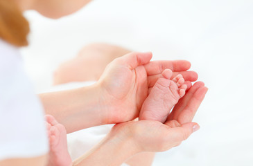 feet newborn baby in arms him mother