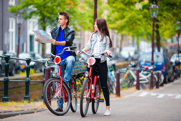 Happy tourists sightseeing city with map on bikes