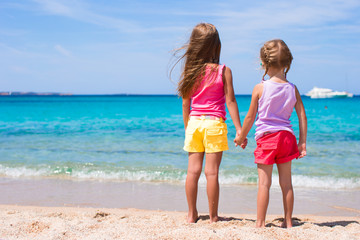 Naklejka premium Adorable little girls at tropical beach during summer vacation